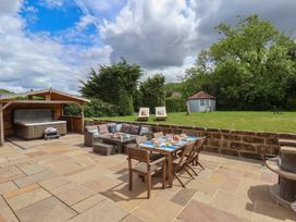 A patio with a hot tub and dining area at 21 Eskdaleside Sleights