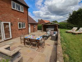 An outdoor patio with furniture and a hot tub at 21 Eskdaleside Sleights
