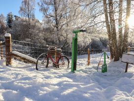 A bicycle next to a bike pump and snow at Wildcat Lodge in Feshiebridge near Aviemore