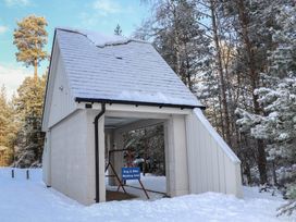 A building with a dog and bike washing area in the snow at Red Deer Lodge Feshiebridge near Aviemore