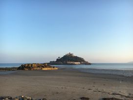 A view of an island with a castle on it from a beach at Stargazy Cottage Praa Sands