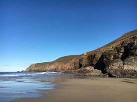 A beach with cliffs and sea at Stargazy Cottage in Praa Sands