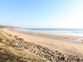 A beach with sand and rocks at Stargazy Cottage in Praa Sands