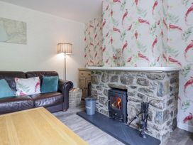 A living room with a stone fireplace and sofa at 8 Glan Ysgethin in Barmouth