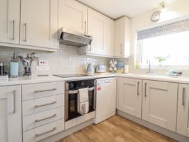 A kitchen with cabinets and appliances at 8 Glan Ysgethin in Barmouth