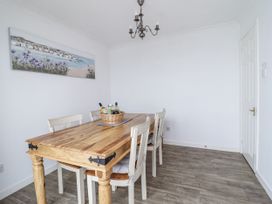 A dining room with a wooden table and chairs at 8 Glan Ysgethin in Barmouth