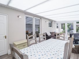 A conservatory with a dining table and chairs at 8 Glan Ysgethin in Barmouth