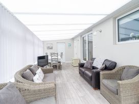 A conservatory with seating and dining area at 8 Glan Ysgethin in Barmouth