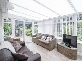 A conservatory with seating and a television at 8 Glan Ysgethin Barmouth