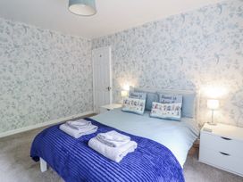 A bedroom with a bed and bedside tables at 8 Glan Ysgethin Barmouth