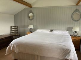 A bedroom with a bed, lamp, mirror, chair, and dresser at The Granary near Kirkby Lonsdale