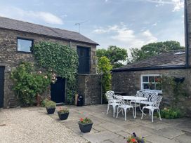 An outdoor seating area with a table and chairs at The Granary in Mansergh near Kirkby Lonsdale