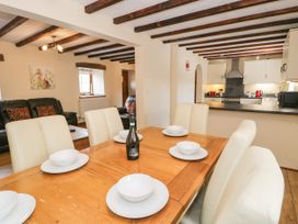 A dining room with a table and chairs at Stabal-y-Gwedd in Dolwen near Abergele