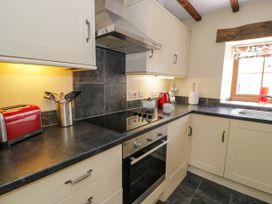 A kitchen with a stove and sink at Stabal-y-Gwedd in Dolwen near Abergele