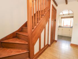 A hallway with stairs and a door leading to the kitchen at Stabal-y-Gwedd in Dolwen near Abergele