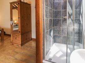 A shower and wooden cabinet in a bedroom at Stabal-y-Gwedd Dolwen near Abergele