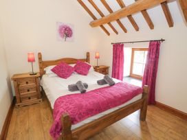 A bedroom with a bed and nightstands at Stabal-y-Gwedd in Dolwen near Abergele