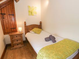 A bedroom with a single bed and a bedside table at Stabal-y-Gwedd in Dolwen near Abergele