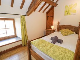 A bedroom with a bed and window at Stabal-y-Gwedd in Dolwen near Abergele