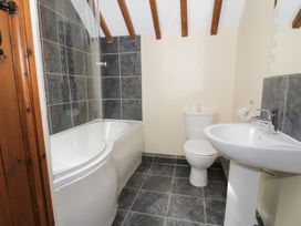 A bathroom with a bathtub, toilet, and sink at Stabal-y-Gwedd, Dolwen near Abergele