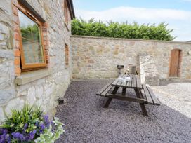 An outdoor seating area with a table and chairs at Stabal-y-Gwedd in Dolwen near Abergele