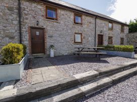 An outdoor area with a picnic table and stone wall at Beudy Bach in Dolwen near Abergele