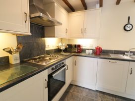A kitchen with stove and sink at Beudy Bach Dolwen near Abergele