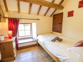 A bedroom with a bed and window at Beudy Bach in Dolwen near Abergele