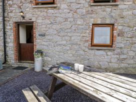 An outdoor area with a table and cups at Beudy Bach Dolwen near Abergele