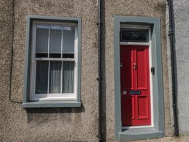 A red door and window on a textured wall at Number Thirty-Nine in Ulverston