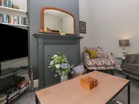 A living room with a bookshelf and armchair at Number Thirty-Nine Ulverston