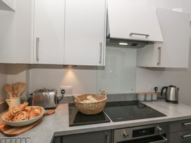 A kitchen with a cooker, toaster, kettle, and a basket of croissants at Number Thirty-Nine in Ulverston