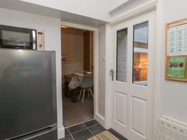 A kitchen with a refrigerator and a door leading to another room at Number Thirty-Nine, Ulverston