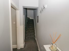 A hallway with stairs and wall hooks at Number Thirty-Nine in Ulverston