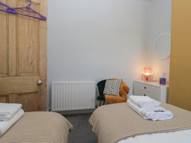 A bedroom with towels on the bed and a lamp on the dresser at Number Thirty-Nine in Ulverston