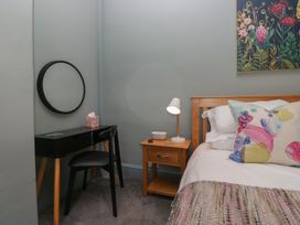 A bedroom with a bed, nightstand, and desk at Number Thirty-Nine in Ulverston