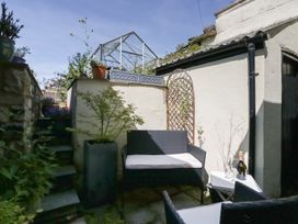 A garden with seating and a greenhouse at Number Thirty-Nine in Ulverston
