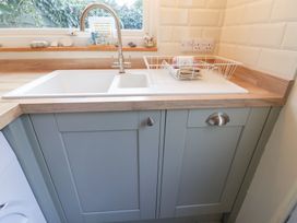 A kitchen with a sink and dish rack at Cobbler's Cottage in Mundesley