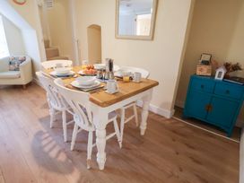 A dining room with a table set for breakfast at Cobbler's Cottage in Mundesley