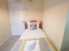 A single bed with a pillow and towel in a bedroom at Cobbler's Cottage in Mundesley