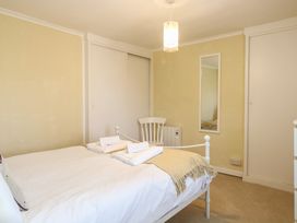 A bedroom with a bed and chair at Cobbler's Cottage in Mundesley
