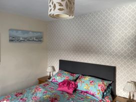 A bedroom featuring a bed with floral bedding at Willow Nook in Glaisdale near Lealholm