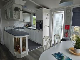 A kitchen with cabinets and an island at Caban Tywod in Abersoch