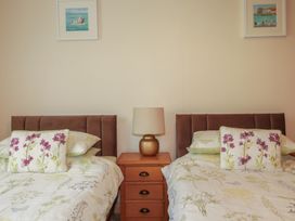 A bedroom with two beds and a nightstand at Underlanes in Boscastle