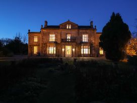 A house with illuminated windows and a garden at Milton Manor in Milton On Stour
