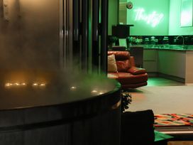 A living area with a hot tub and kitchen at Milton Manor in Milton On Stour