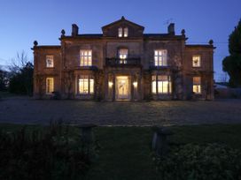 A large house with lights on at Milton Manor in Milton On Stour