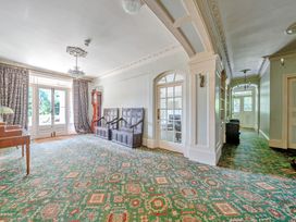 A living room with a chandelier and wooden furniture at Milton Manor in Milton On Stour