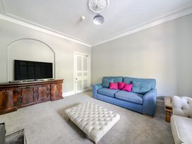 A living room with a sofa and a television at Milton Manor in Milton On Stour