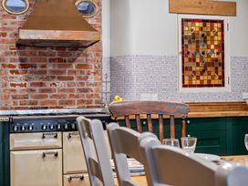A kitchen with a stove and exhaust hood at Milton Manor in Milton On Stour